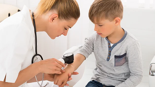 Dermatologin Hautärztin untersucht Kind mit Neurodermitis Richtige Diagnose