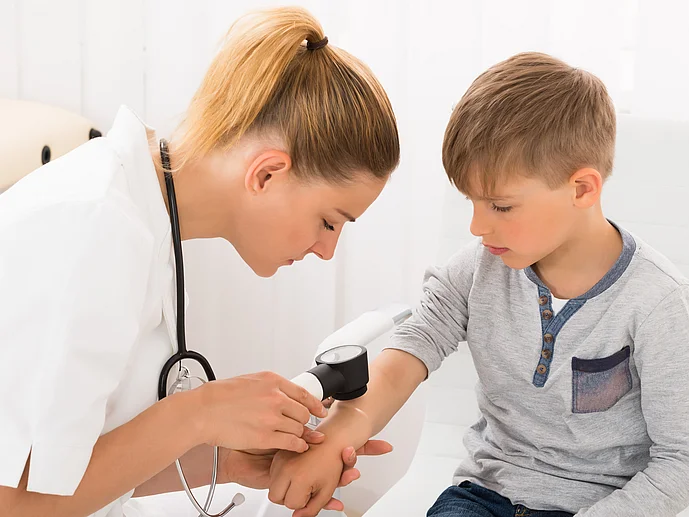 Dermatologin Hautärztin untersucht Kind mit Neurodermitis Richtige Diagnose