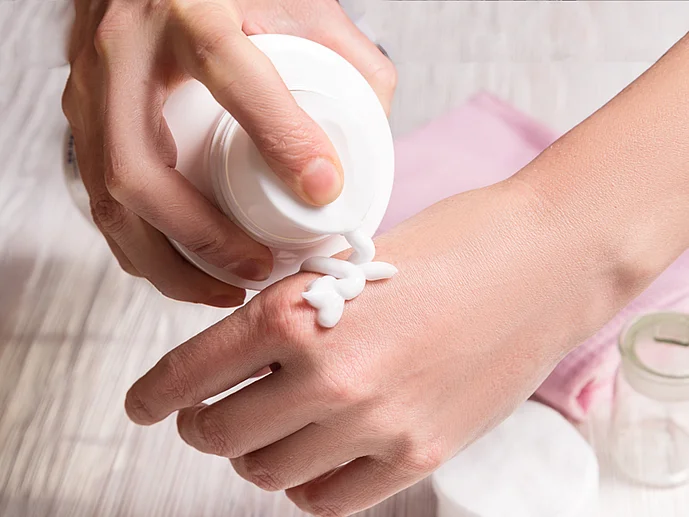Hautpflege Neurodermitis an Händen medizinische Creme Frau cremt Hand ein