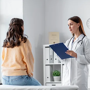 Dermatologe untersucht Patientin mit Neurodermitis