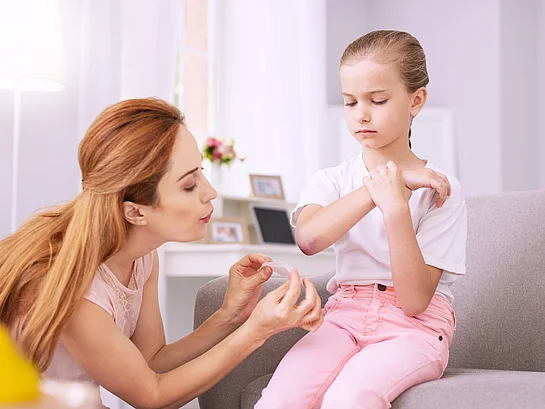 Wundheilung Mutter versorgt Wunde beim Kind